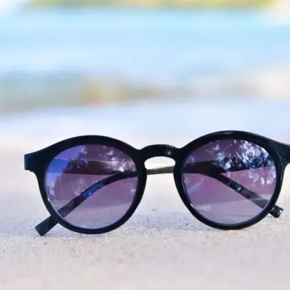 Black cat‑eye sunglasses with purple lenses.